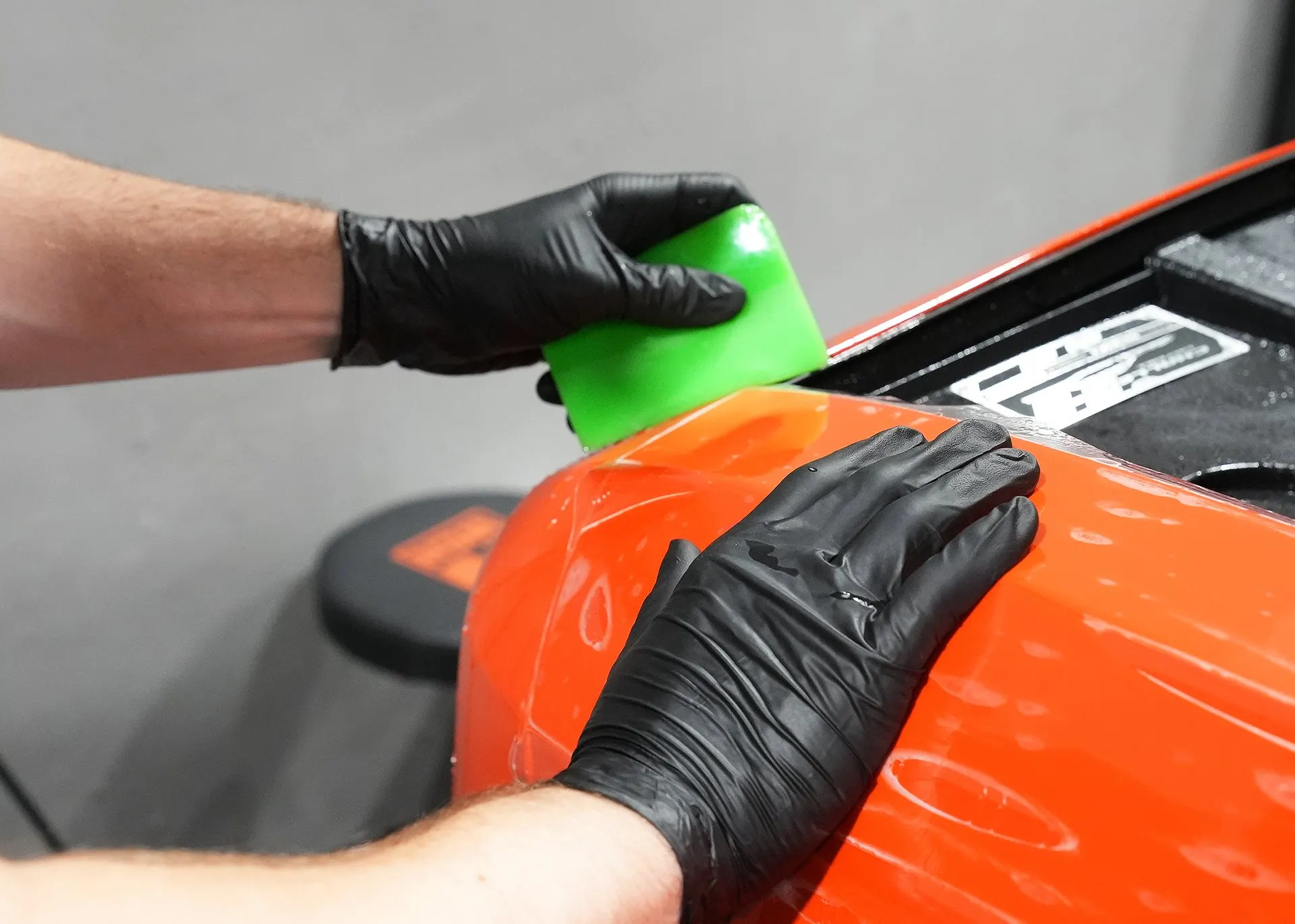 A gloved hand wrapping film around a panel edge